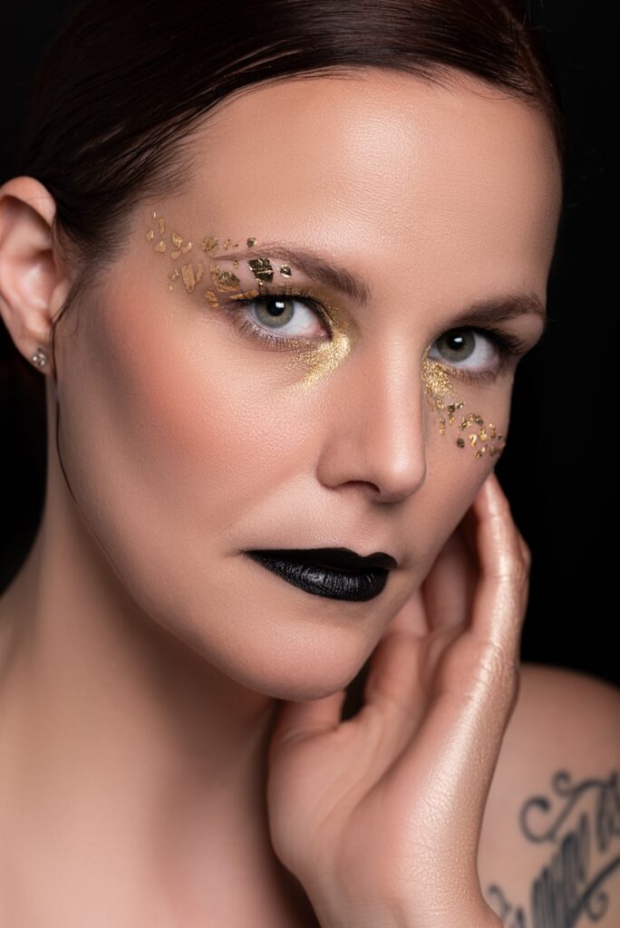 Makeup mit Gold und schwarzen Lippen